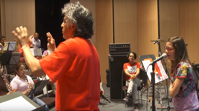 Santa María dirige el ensayo de frente a los músicos de la banda de Tlayacapan. A su derecha, Natalia canta. Al fondo, se distingue el guitarrista.